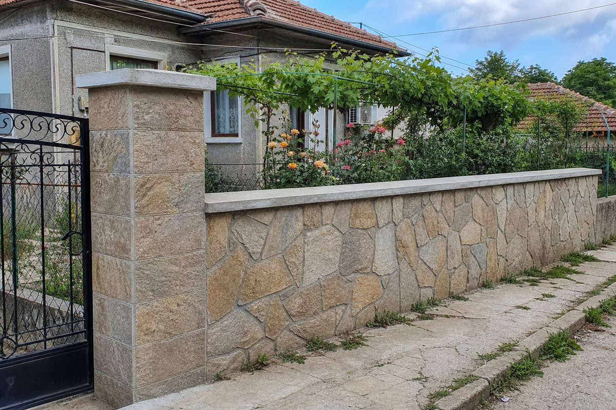Sample demo image of a completed modest stone boundary wall outside a Bulgarian house