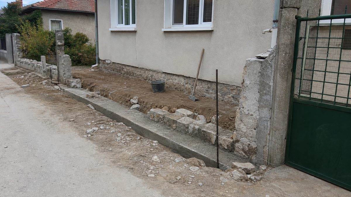 Sample demo image of the early stage of a boundary wall rebuild with rubble cleared and a foundation trench visible